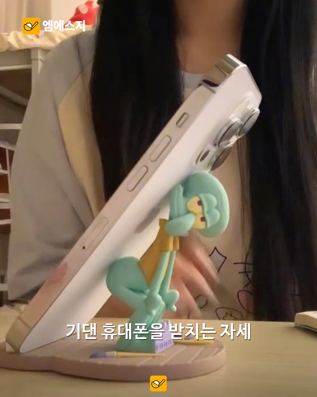 “징징이 엉덩이가 내 폰을?” KKV×스폰지밥 거치대, 책상 위 캐릭터 굿즈 3 징징이 거치대에 휴대폰을 기대 놓은 사용 예시